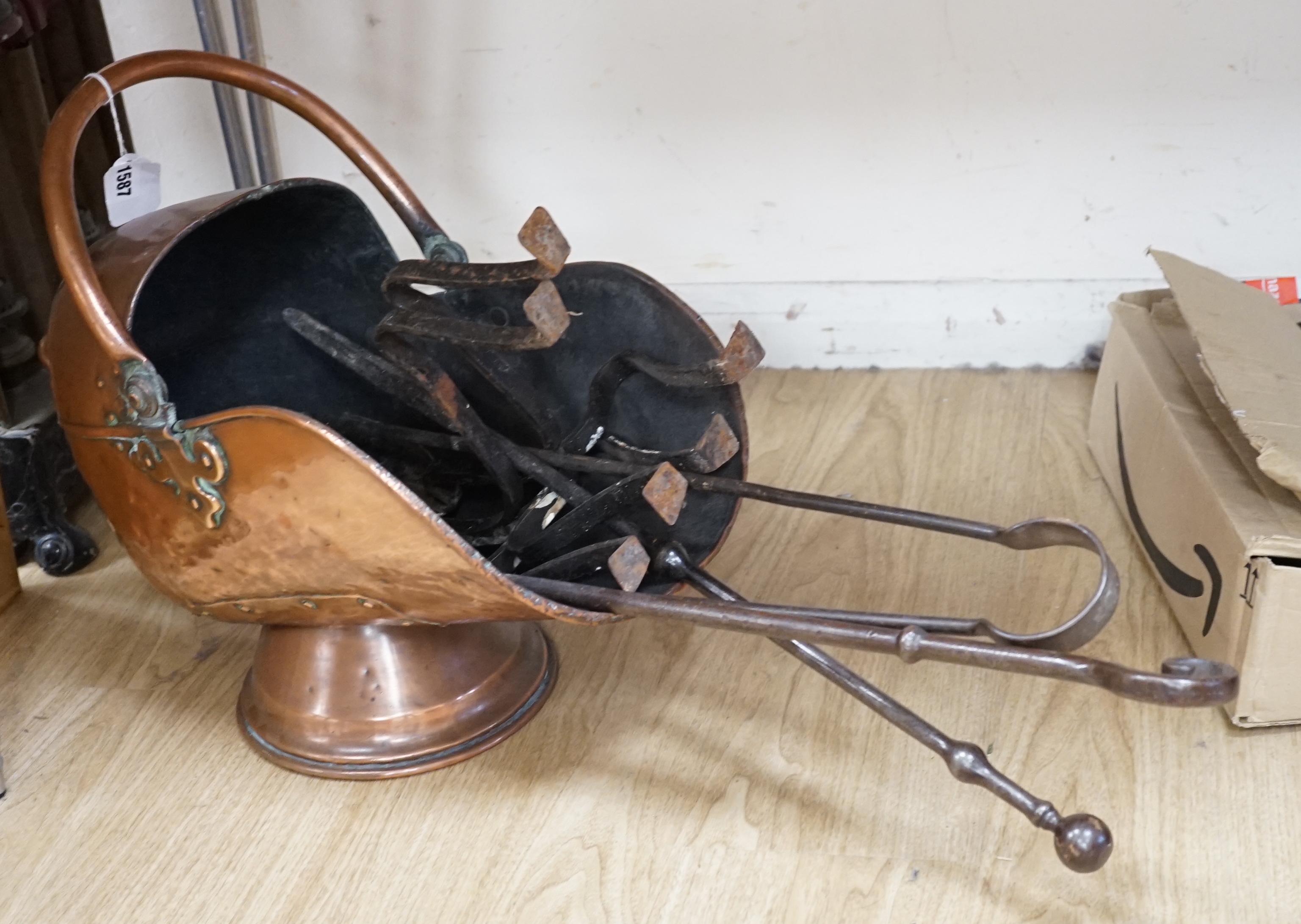 A pair of copper shield shaped fire dogs in Arts & Crafts style, together with further fireside effects